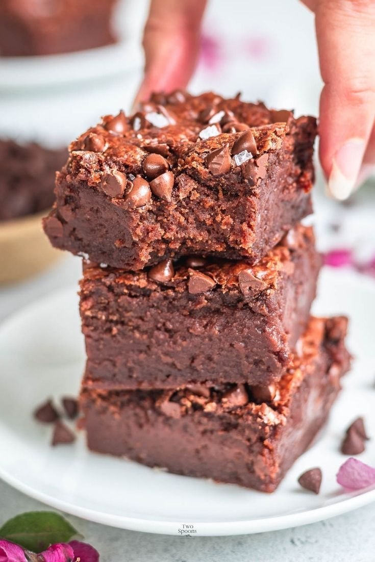 Fudgy chocolate brownies stacked on a board